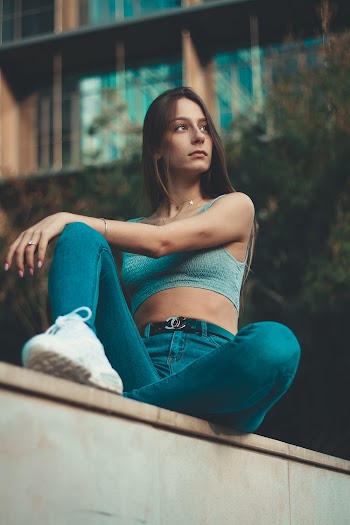 Woman Sitting on Pavement Near Building