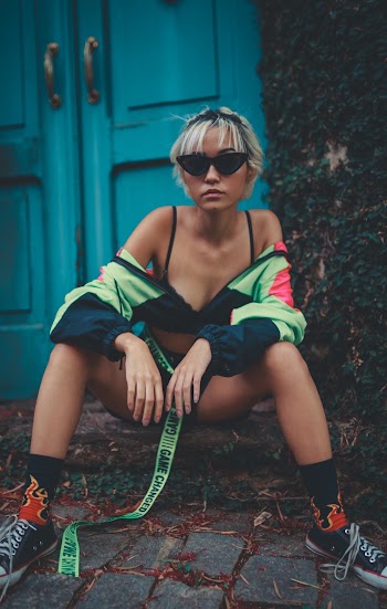 Woman Sitting on Pavement While Wearing Sunglasses