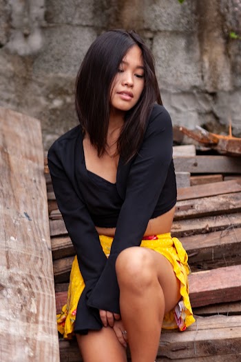 Woman Sitting on Pile of Firewood