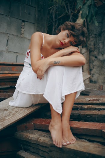 Woman Sitting on Pile of Wood