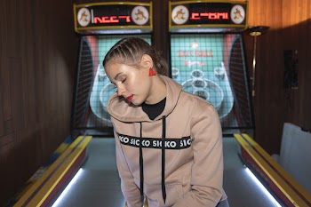 Woman Sitting on Pinball Machine