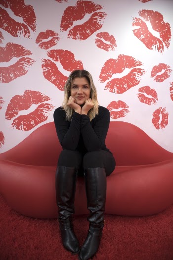 Woman Sitting on Red Lips Sofa Inside Room