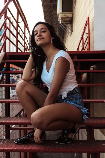 Woman Sitting On Red Metal Stairs
