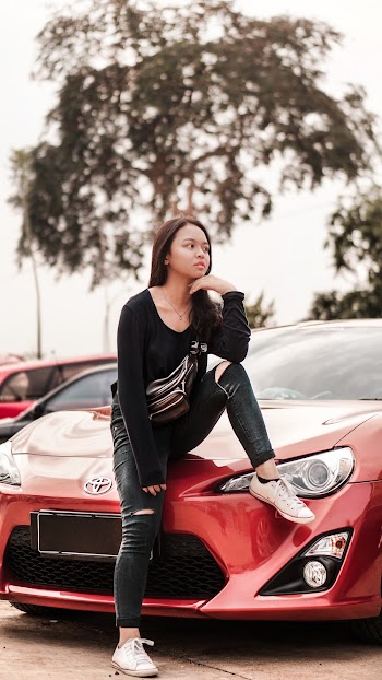Woman Sitting On Red Toyota Car