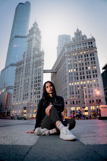 Woman Sitting on Road Overlooking High-rise Buildings
