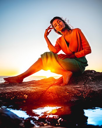 Woman Sitting on Rock During Golden Hour