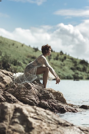 Woman Sitting on Rock Near Body of Water