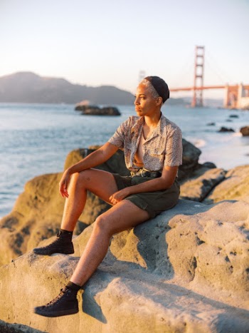 Woman Sitting on Rock Near Sea