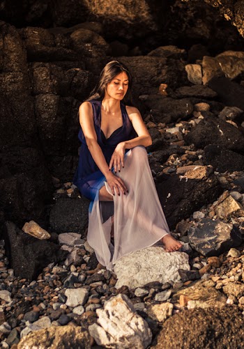 Woman Sitting on Rocks Looking Down