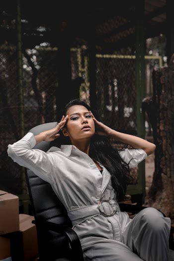 Woman Sitting On Rolling Chair Touching Her Head