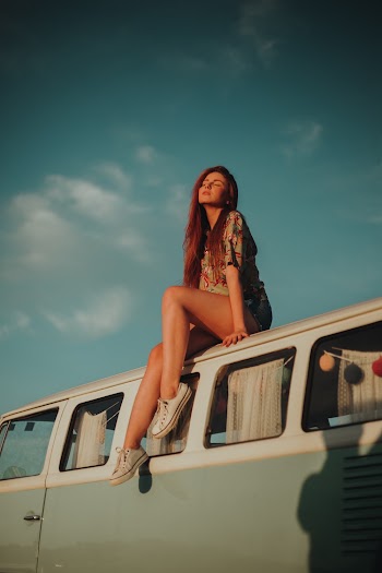Woman Sitting on Roof of a Vehicle