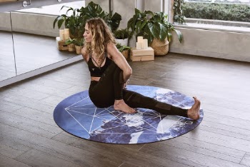 Woman Sitting on Round Mat While Twisting Her Body