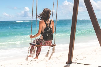 Woman Sitting on Seashore Swing