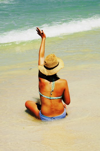 Woman Sitting on Shore Waving Hands