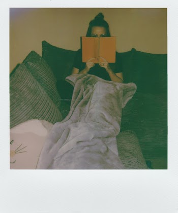 Woman Sitting On Sofa Reading Book