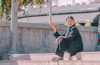 Woman Sitting on Stair Wearing Black Coat and Holding Cigarette Stick