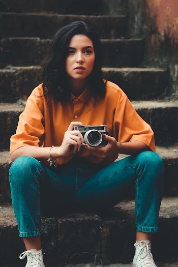 Woman Sitting on Stairs Holding Camera