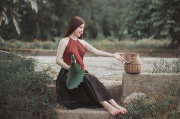 Woman Sitting on Star Beside Brown Wicker Basket Durng Daytime