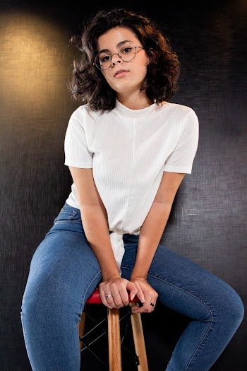 Woman Sitting on Stool Wearing White Shirt and Blue Jeans