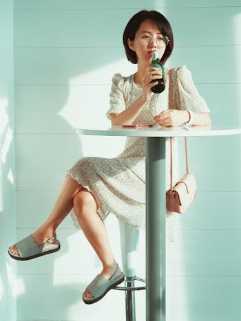 Woman Sitting On Stool While Holding Bottle