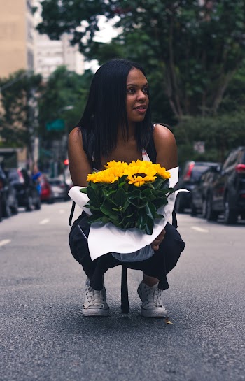 Woman Sitting on Stree and Carrying Sunflower