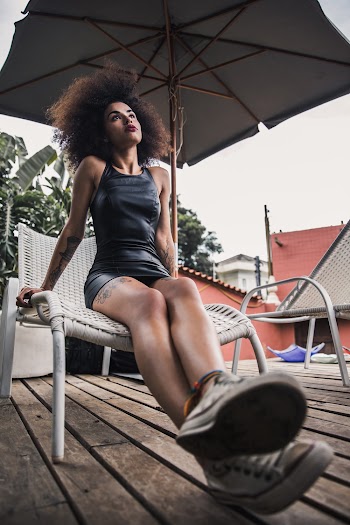 Woman Sitting on Sunlounger Near Parasol