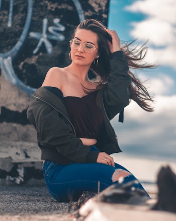 Woman Sitting on Surface Touching Her Hair