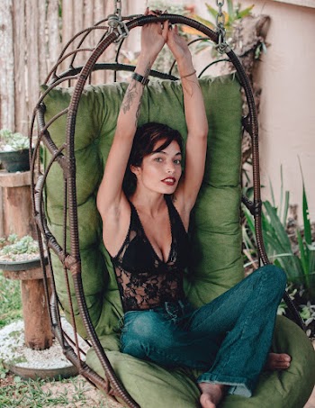 Woman Sitting on Swing Chair While Holding on Chair