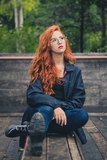 Woman Sitting On Table Wearing Black Jacket
