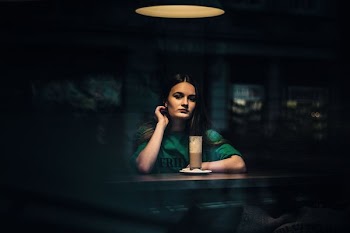woman sitting on table with drink