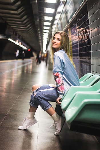 Woman Sitting on Teal Gang Chair on Train Station