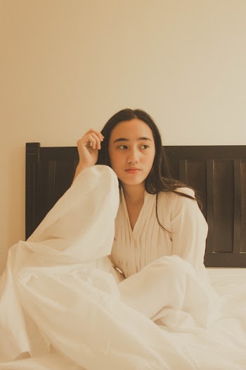 Woman Sitting on the Bed Wearing White Dress