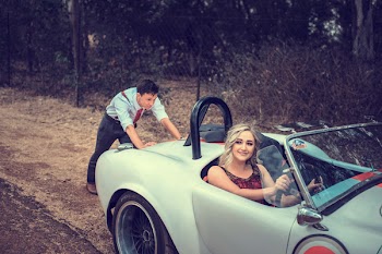 Woman Sitting on the Car While Man Pushing It