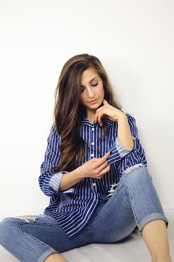Woman Sitting On The Floor Rolling Her Blue Striped Dress Shirt