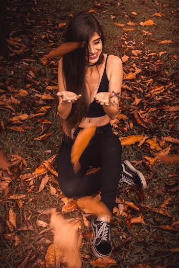 Woman sitting on the ground with brown leaves