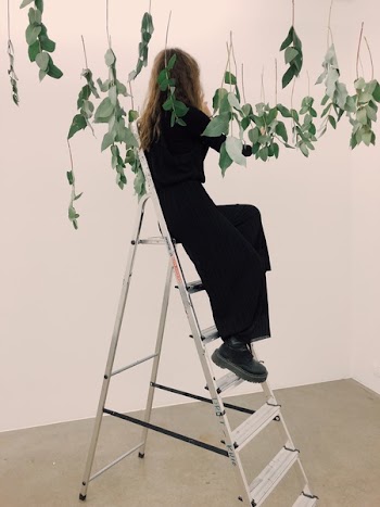 Woman Sitting on Tip of Ladder