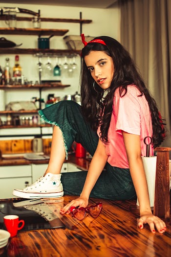 Woman Sitting On Top Of Wooden Dining Table