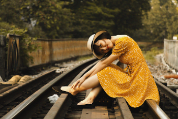 Woman Sitting on Train Tracks