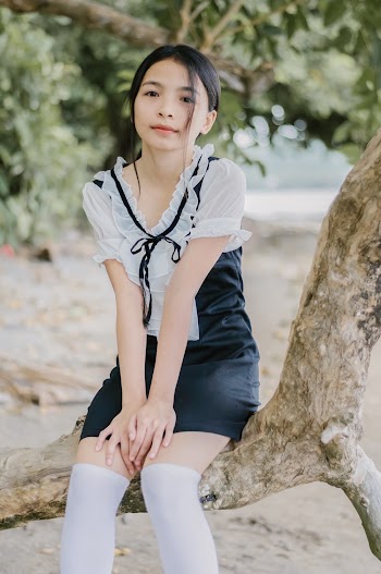 Woman Sitting on Tree Trunk