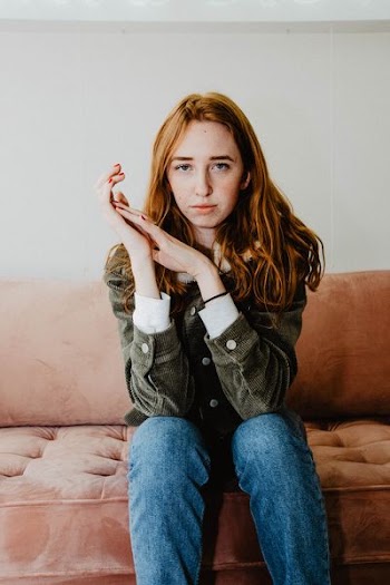 woman sitting on tufted sofa