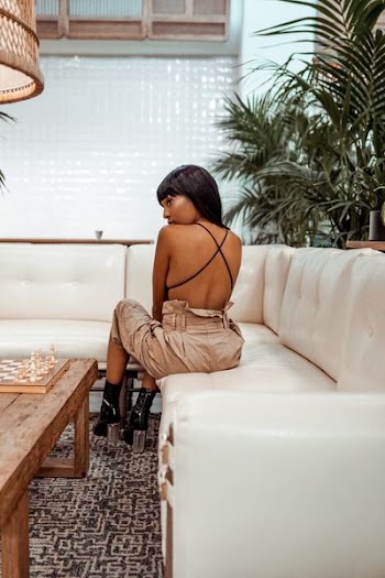 woman sitting on white leather sectional sofa