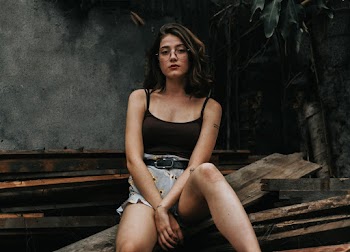 Woman Sitting on Wood Board Near Tree