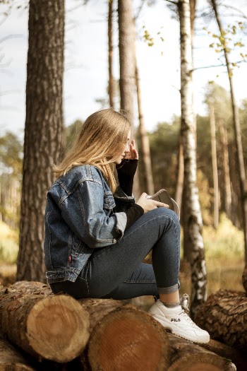 Woman Sitting on Wood Logs