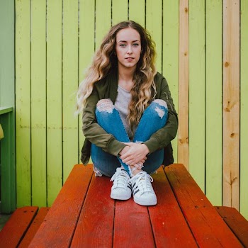 woman sitting on wooden table during daytime