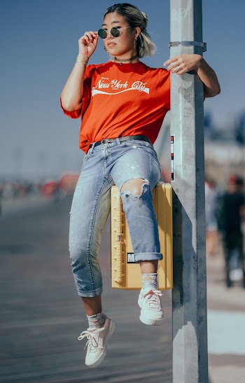 Woman Sitting on Yellow Box Attached On Post