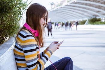 Woman Sitting Outdoors While Using Smartphone