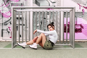 Woman Sitting Right Next to Gray Metal Rail