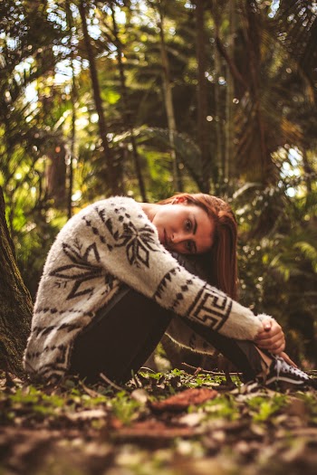 Woman Sitting Surrounded by Trees on Focus Photography