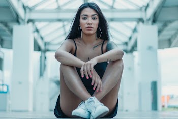 Woman Sitting While Crossing Her Legs