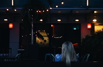 woman sitting while facing towards bar